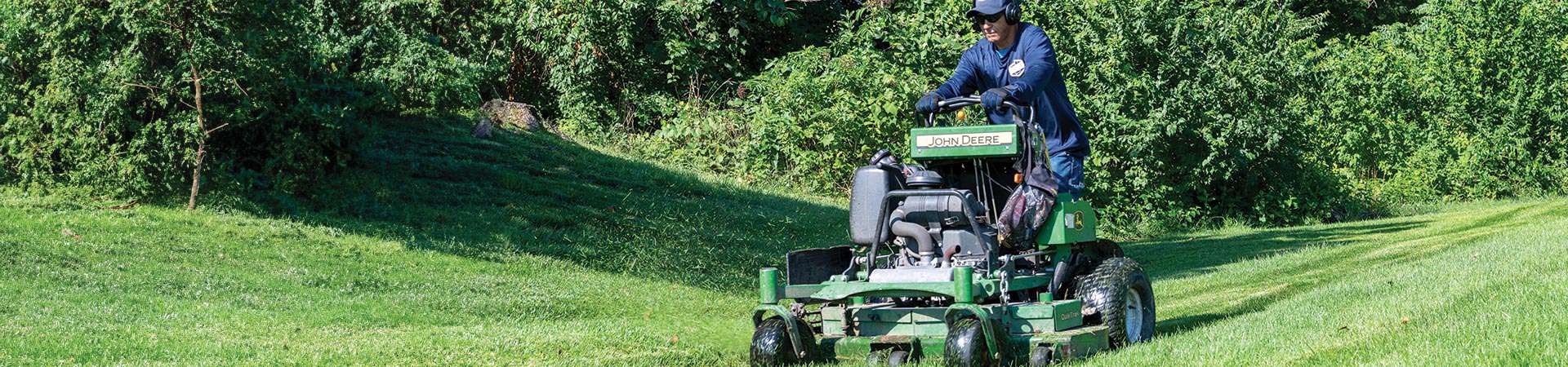 Man Cutting Grass In A Property Management Services