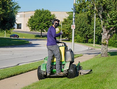 Manual Worker Mowing The Lawn