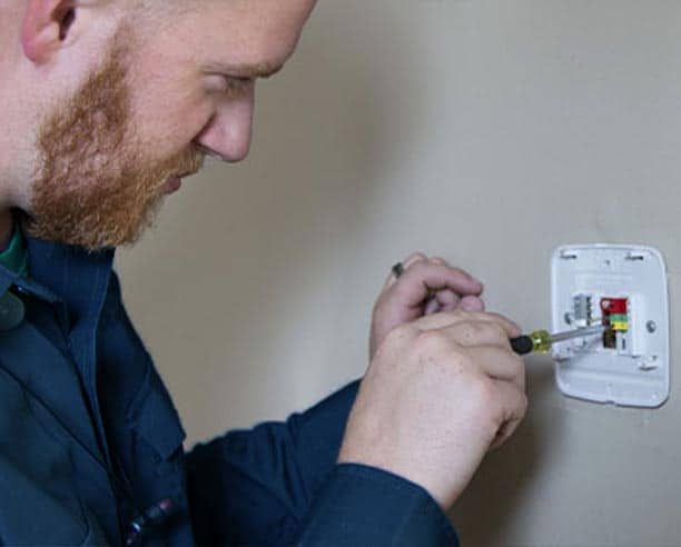 Man Fixing Electrical Wall Socket With Screwdriver