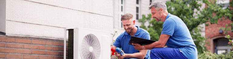two men conducting HVAC repair on an outside unit
